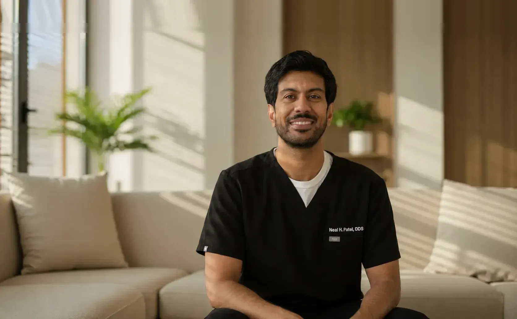 Dr. Neal H. Patel, dentist and owner of Oak Hills Dentistry, seated in a treatment lounge
