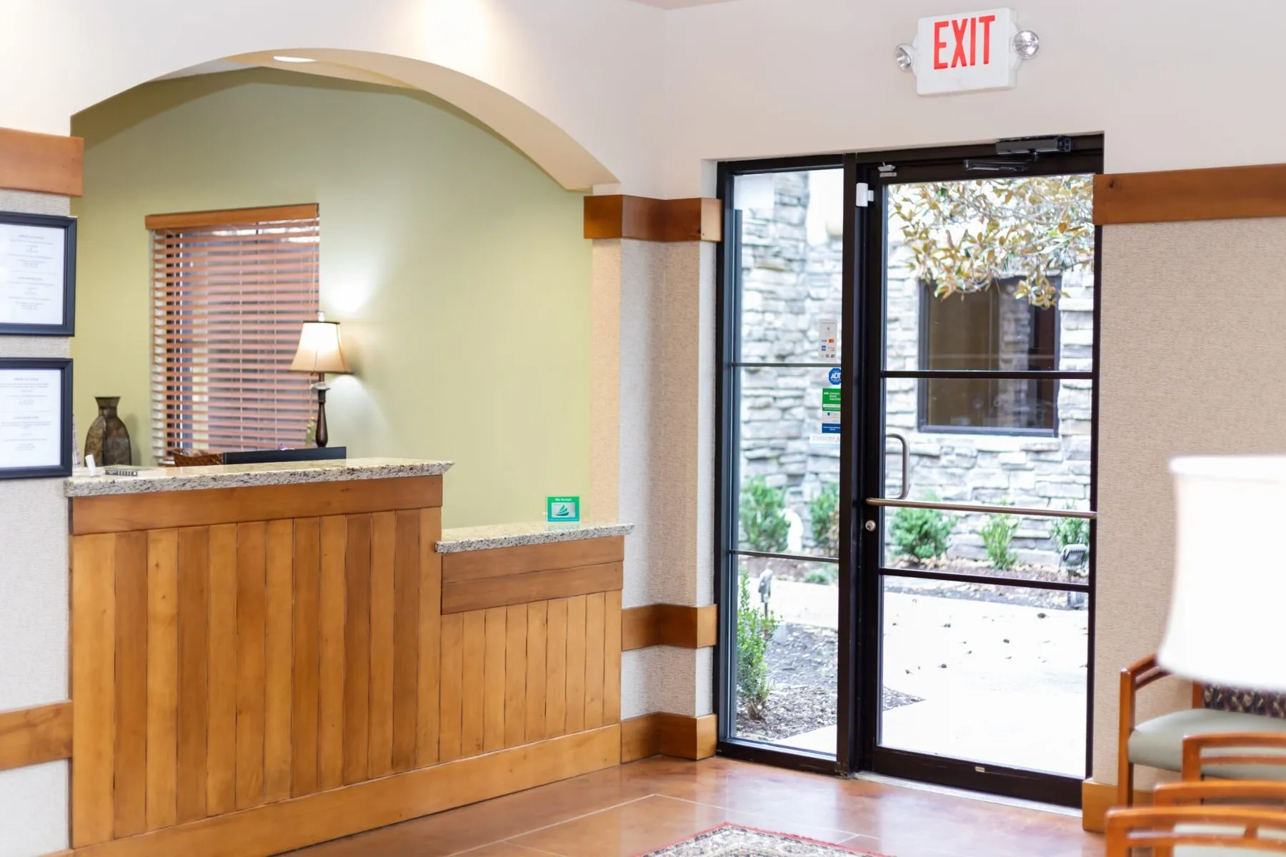 The Oak Hills Dentistry reception desk beside a glass door opening onto greenery