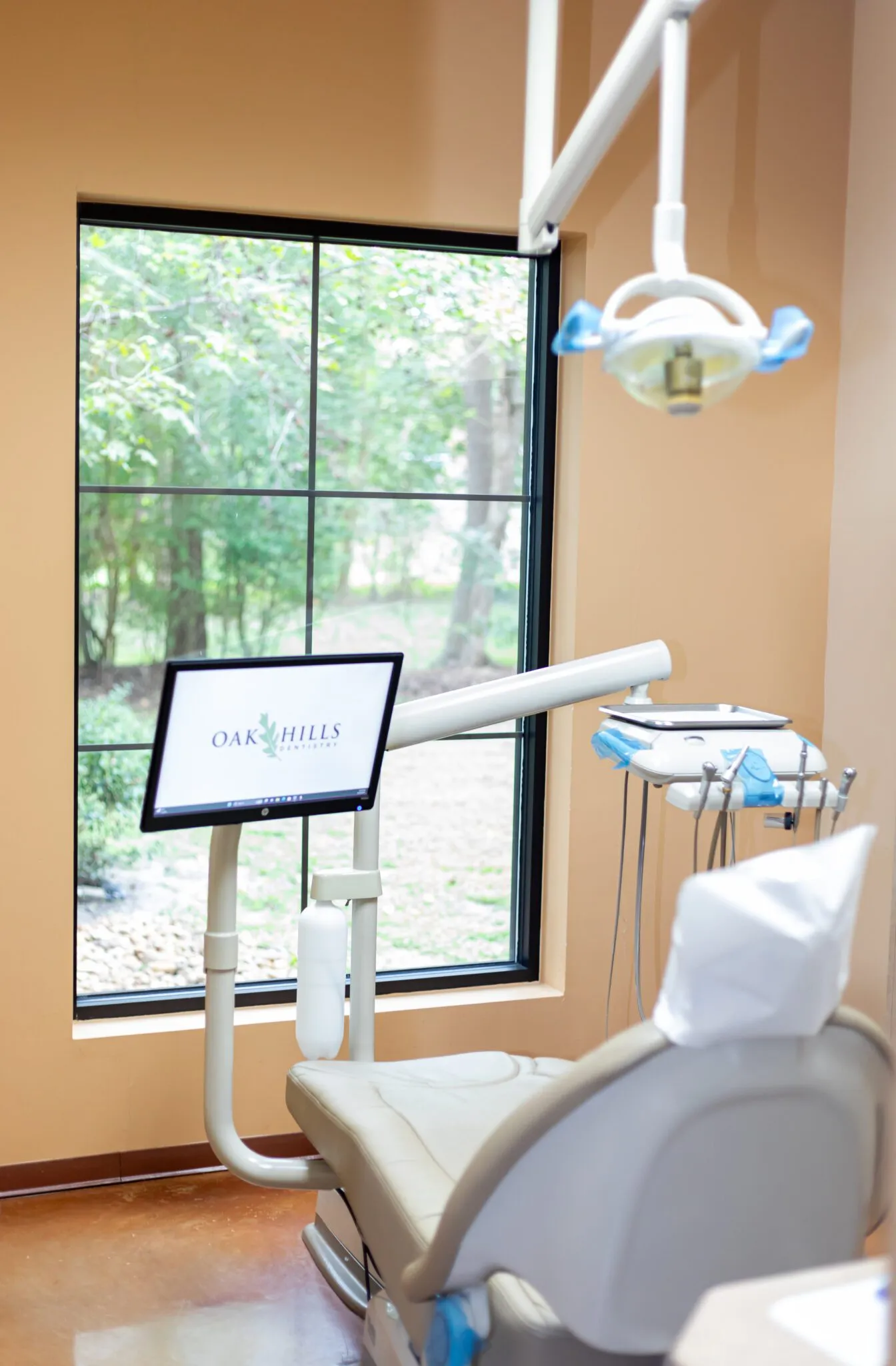 An Oak Hills Dentistry treatment room with the chair positioned beside a large window