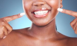 closeup of a woman pointing to her new smile
