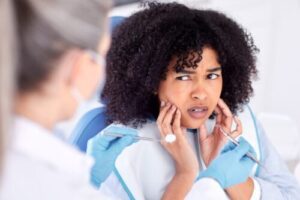 woman holding her mouth in fear of an upcoming root canal, dental anxiety