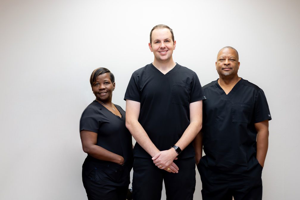 Spring, TX dental team at Oak Hills Dentistry poses for a group photo wearing black scrubs against a white background