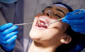 Face, hands and tools with woman at dentist for oral hygiene or dental care appointment closeup. Checkup, healthcare and medical equipment with patient in chair at clinic for mouth cleaning or exam