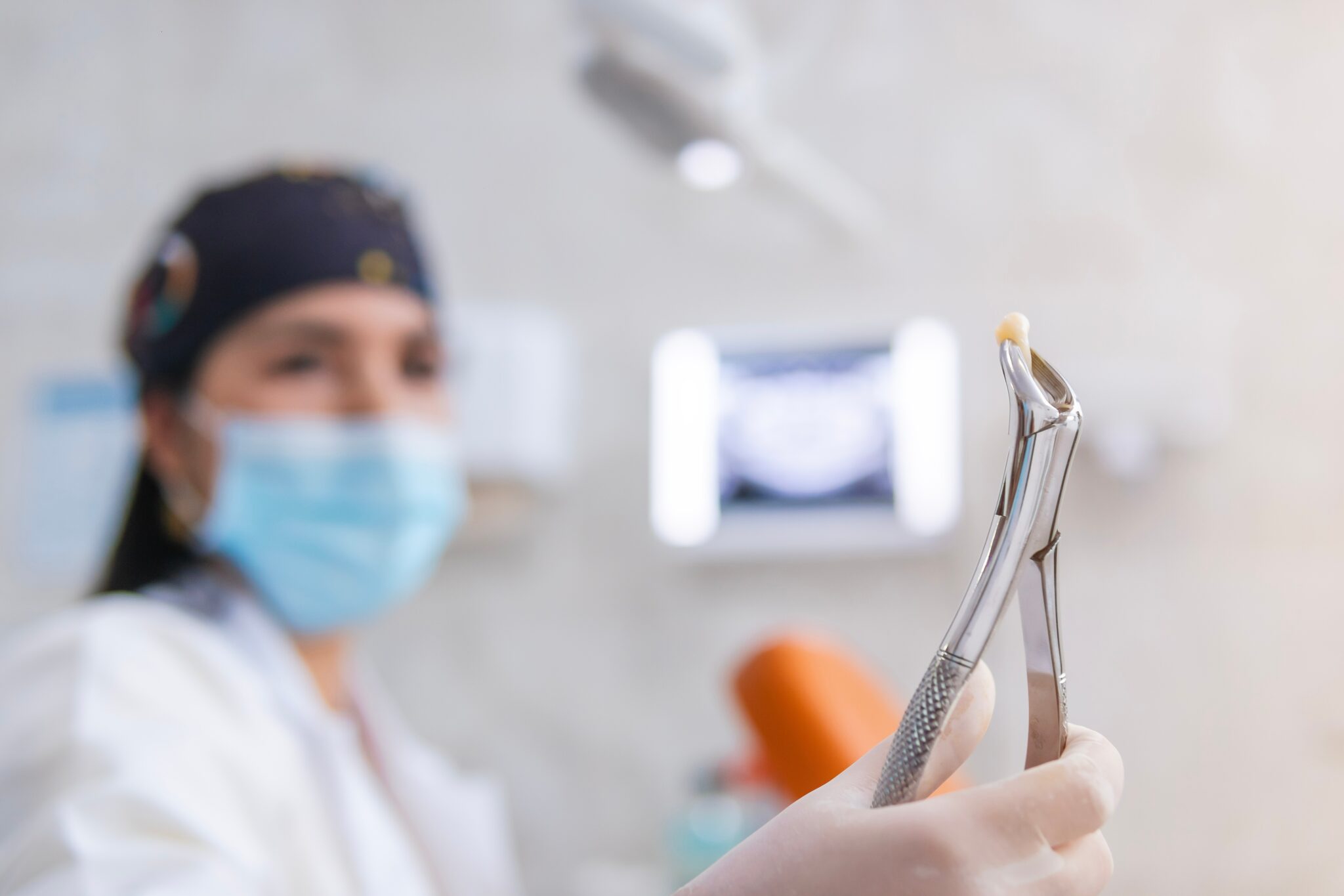 doctor holding up a pulled tooth in Spring