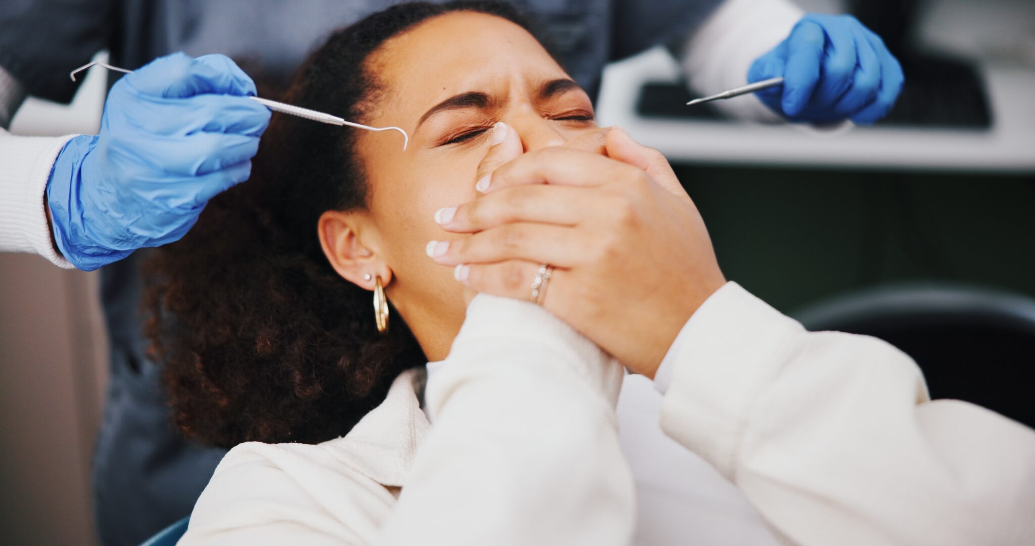 young woman covering her mouth in fear, root canal anxiety