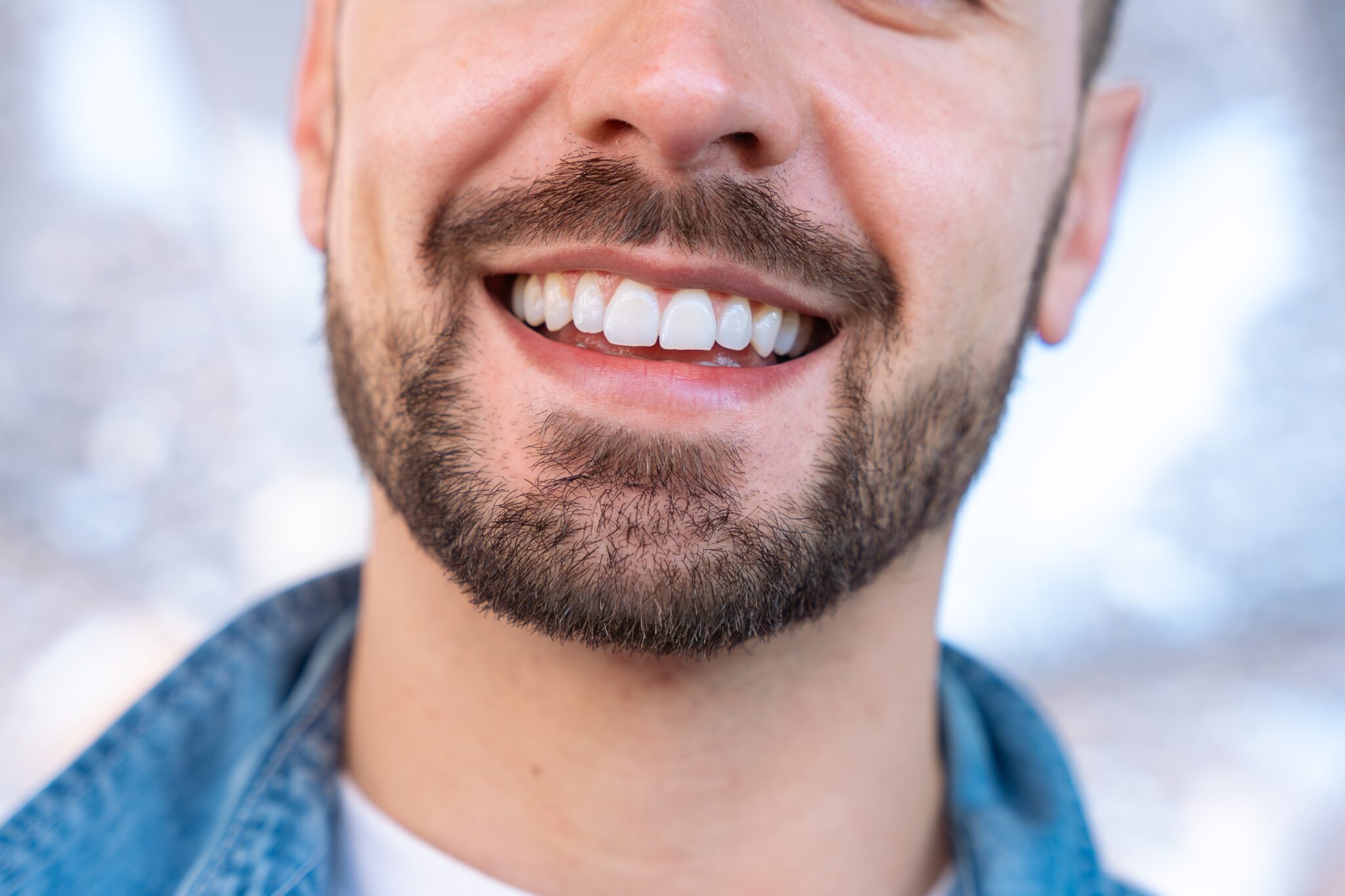 closeup of a man smiling, bright white teeth